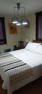 a bedroom with a large white bed with two lights at La Ruta del Jazz in Santa Cruz