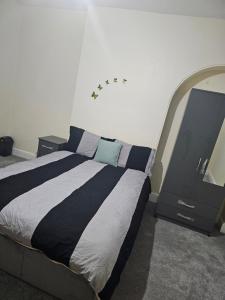 1 dormitorio con 1 cama y TV en VIkky'S BnB, en Birmingham