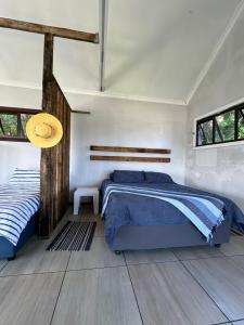 Umngazana的住宿－Blue Lagoon Cottage，一间卧室设有一张床和两个窗户。