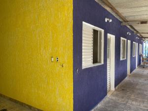 een blauwe en gele muur met een raam en een deur bij Frente ao Mar in Ilha Comprida