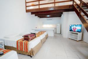 a room with two beds and a television in it at Hotel VillaOeste in Mossoró