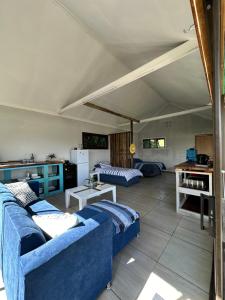 ein Wohnzimmer mit 2 blauen Sofas und einem Tisch in der Unterkunft Blue Lagoon Cottage in Umngazana