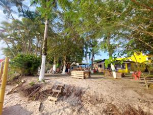 伊利亞孔普里達的住宿－Frente ao Mar，海滩上种有树木和椅子的游乐场