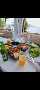 uma mesa com um prato de comida e bebidas em Frente ao Mar em Ilha Comprida