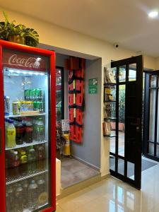 International Hostel Medellin في ميديلين: وجود ثلاجة كوكاكولا في متجر يفتح بابه