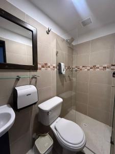 メデジンにあるInternational Hostel Medellinのバスルーム(トイレ、洗面台、鏡付)