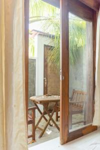an open door to a patio with a table and a chair at Brickwood Ganduvaru Private Villas in Rasdhoo