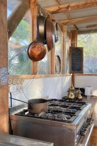 uma cozinha com fogão com panela e frigideiras em Tobiana Desert Lodging Negev em ‘Ezuz