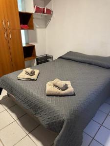 1 dormitorio con 1 cama con toallas en ArquiArts Casa-Departamento en Barrio Huerto del Sol en 