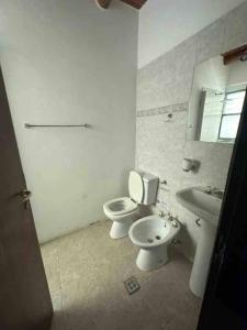 Baño blanco con aseo y lavamanos en ArquiArts Casa-Departamento en Barrio Huerto del Sol en 