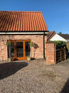a brick house with a wooden door and a fence at The Hideaway: Farnsfield (5 mins from Southwell) in Farnsfield
