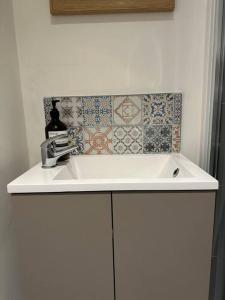 a white sink in a bathroom with tiles on the wall at The Hideaway: Farnsfield (5 mins from Southwell) in Farnsfield