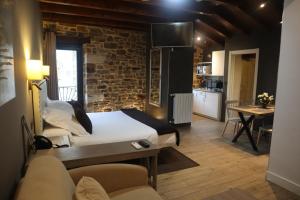 Una habitación con una cama y una cocina con una mesa. en Osabarena Hotela, en Murueta-Orozko