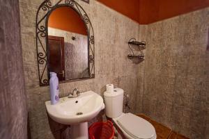Un baño con lavabo, inodoro y espejo. en Chez Brahim vue panoramique, en Aït Ben Haddou 125 fotos más