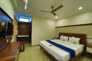 阿布山的住宿－Hotel Mid Town Inn Nakki Lake 500 Metter，一间卧室配有一张大床和吊扇