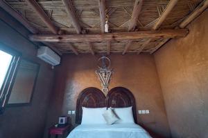 1 cama con cabecero de madera en una habitación en Chez Brahim vue panoramique, en Aït Ben Haddou