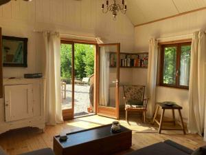 uma sala de estar com uma porta que abre para um pátio em Chalet Au bois du Haut Folin em Saint-Prix