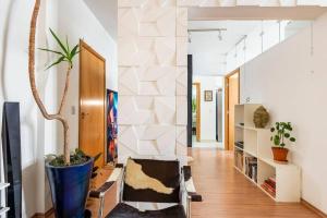uma sala de estar com uma planta e uma escada em Apartamento no Centro - 1 quarto Edifício Copan em São Paulo