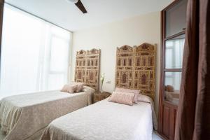 a bedroom with two beds and a window at Casa la Mezquita con parking gratis in Córdoba