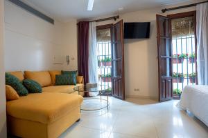 ein Wohnzimmer mit einem Sofa und einigen Fenstern in der Unterkunft Casa la Mezquita con parking gratis in Córdoba