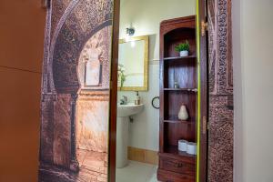 a bathroom with a wooden door and a sink at Casa la Mezquita con parking gratis in Córdoba