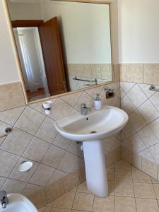 a bathroom with a sink and a mirror and a toilet at Baglio Quadrone bovo Marina in Montallegro