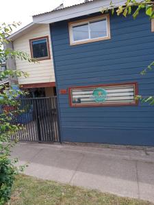 una puerta de garaje azul con un cartel en ella en Hospedaje Martita Patagonia en Coihaique