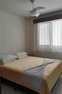 - une chambre avec un lit et un ventilateur de plafond dans l'établissement Hochheim Beachside Itapema, à Itapema