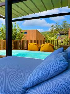 1 dormitorio con cama y piscina en Nidos de carnota, en San Mamede de Carnota