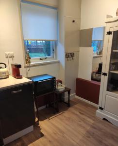 a kitchen with a window and a table with a chair at Appartement Ruinerwold in Ruinerwold