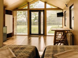 Un dormitorio con una cama, un escritorio y ventanas. en Bereg holiday park, en Svetlogorskoye