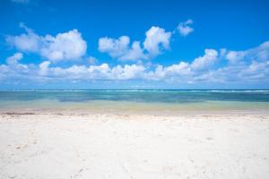 a beach with the ocean and clouds in the sky at Coral Kai home in Driftwood Village