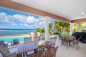 an outdoor patio with tables and chairs and the ocean at Coral Kai home in Driftwood Village