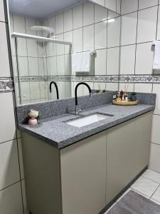 a bathroom with a sink and a mirror at La Vita hospedaria studio verde in Nova Veneza +30 photos
