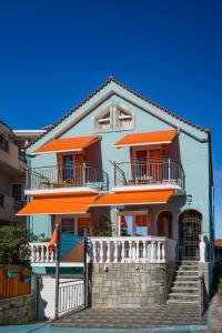 une grande maison avec des balcons orange et des escaliers dans l'établissement Belleza Villa, à Lixouri