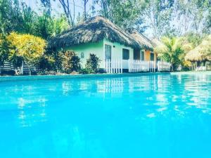 una casa con piscina frente a ella en Las Dunas Surf Resort, en Aposentillo