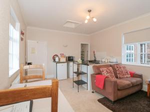 a living room with a couch and a kitchen at Wards Court 1 in Gloucester