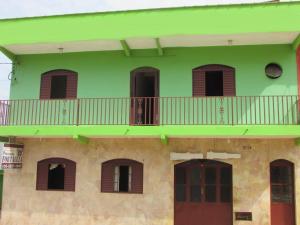 un edificio verde con balcón en la parte superior. en Pousada Fortaleza São Thomé, en São Thomé das Letras
