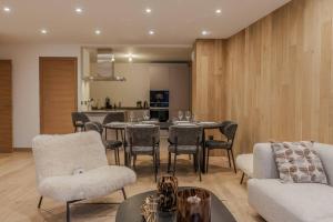 a living room with a table and chairs and a kitchen at Appartement LABBY 01 Courchevel 1650 in Courchevel
