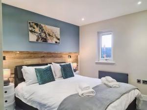 ein Schlafzimmer mit 2 Betten und Handtüchern darauf in der Unterkunft Modern Luxury Apartment in Bishops Cleeve