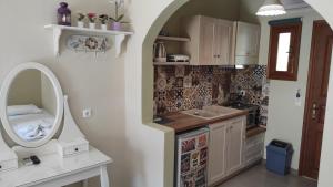 a small kitchen with a sink and a mirror at Kallisti Seaside Studios Skopelos in Agnontas +47 photos