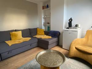 sala de estar con sofá azul y almohadas amarillas en Bed and breakfast Carma Arnhem en Arnhem