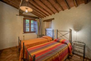 sypialnia z 2 łóżkami i oknem w obiekcie Agriturismo Antico Borgo Montacuto w mieście Pari