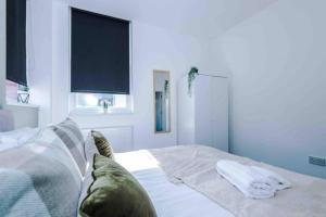 a bedroom with a bed with white sheets and a window at Spacious One-Bedroom Apartment in Saint Helens in Saint Helens +14 photos