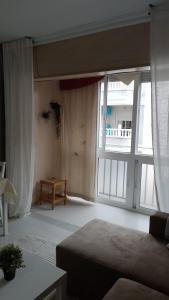 a living room with a bed and a large window at Apartamneto Vicente Blasco Ibañez in Torrevieja