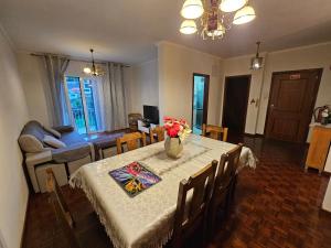 Un comedor con una mesa con un jarrón de flores encima. en SAO PEDRO APARTMENT, en Santa Cruz