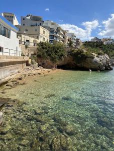 - une plage avec des personnes nageant dans l'eau dans l'établissement 2 Bedroom apartment close to the beach, à San Pawl il-Baħar