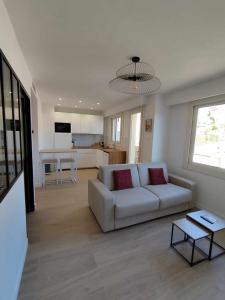 a living room with a white couch and a kitchen at Appartement moderne refait à neuf - 4 couchages - MENTON in Menton