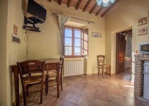 d'une salle à manger avec une table, des chaises et une fenêtre. dans l'établissement Agriturismo Antico Borgo Montacuto, à Pari