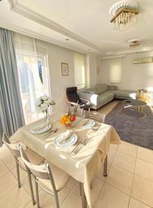 uma sala de estar com uma mesa e um sofá em Zerrin Hanım Apartments - 1 minute from Kleopatra Beach em Alanya